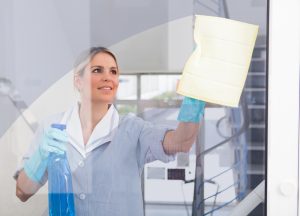 Female cleaner polishing a window